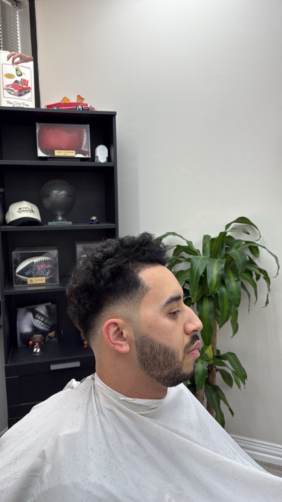 Styled dark hair with faded sides and a shaped beard